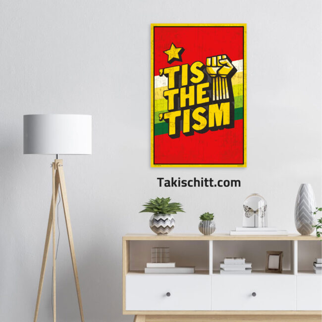 Tis The Tism poster being displayed on a light grey wall above a sideboard, next to a white and wood lamp
